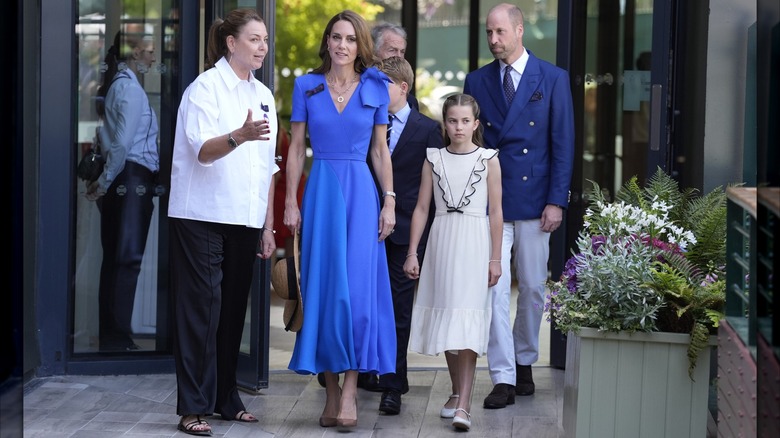 Princess Charlotte walks with Princess Catherine and Prince William