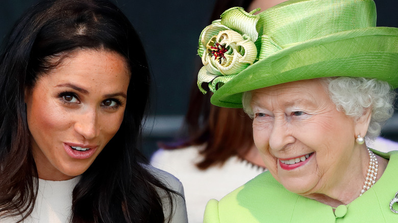 Meghan Markle and Queen Elizabeth II sitting next to each other whispering