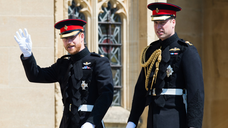 Princes Harry and William in uniform walking into Harry's wedding