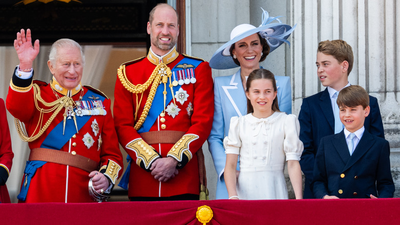 King Charles III waving next to Prince William, Kate Middleton, and their children