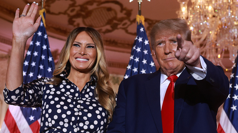 Melania Trump waving while Donald points