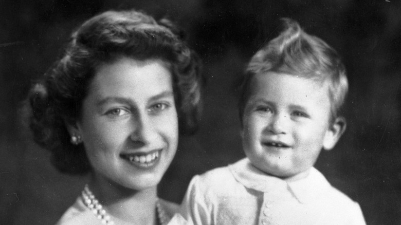 Queen Elizabeth II smiling with Prince Charles on his first birthday