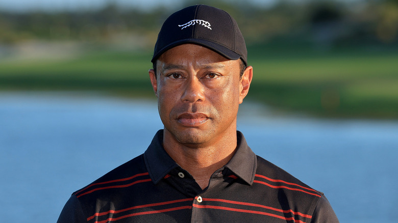 Tiger Woods looking serious red and black striped shirt