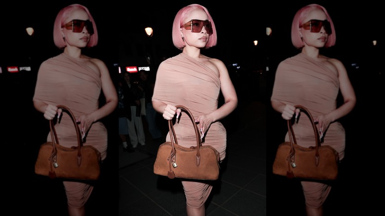 Ice Spice wearing sunglasses and carrying a purse