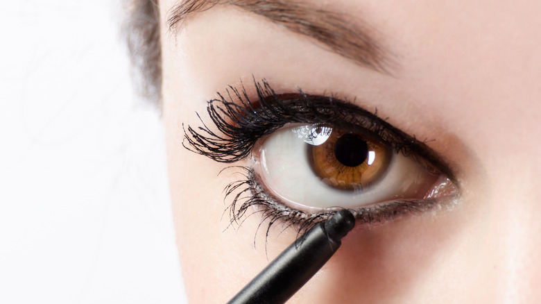 closeup of a woman applying eyeliner 
