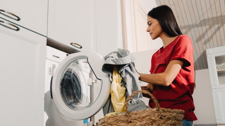 Woman putting clothes in washer