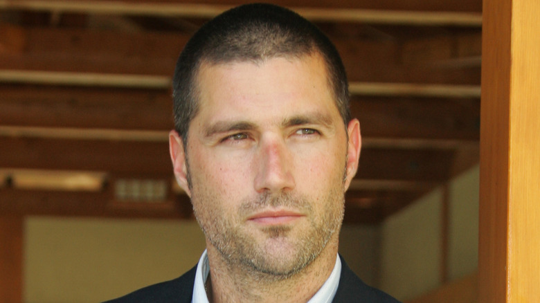 Younger Matthew Fox with a small smile and staring at something off-screen.