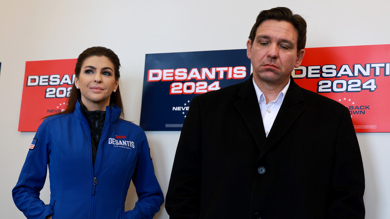 Ron DeSantis and Casey DeSantis standing in front of DeSantis 2024 campagin signs