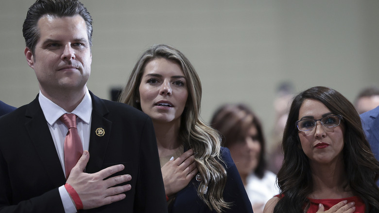 Matt Gaetz, Ginger Gaetz, and Lauren Boebert standing together with their hands over their hearts