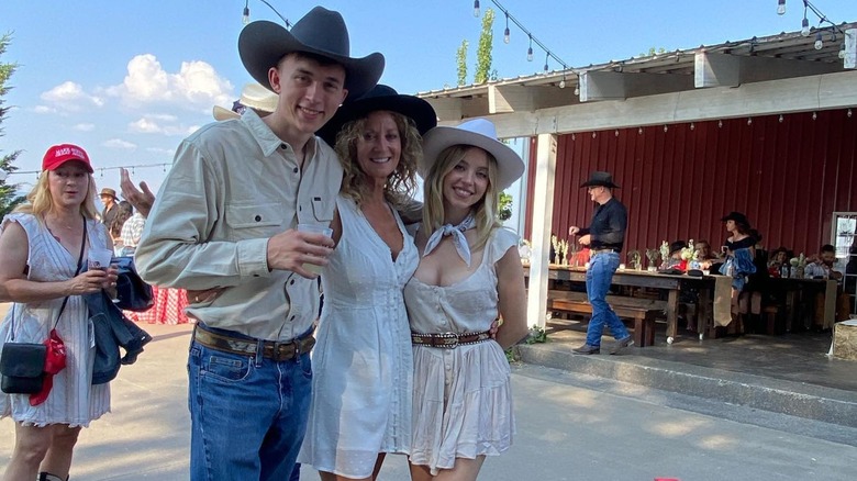 Sydney Sweeney posing with family members in a cowboy hat.