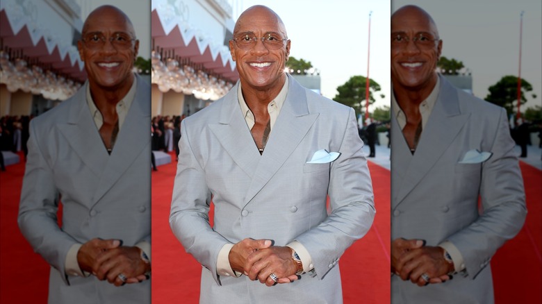 Dwayne Johnson smiling while wearing a silver blazer