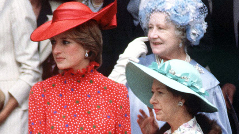 A smiling Queen Mother and Princess Margaret standing next to an unsmiling Princess Diana.