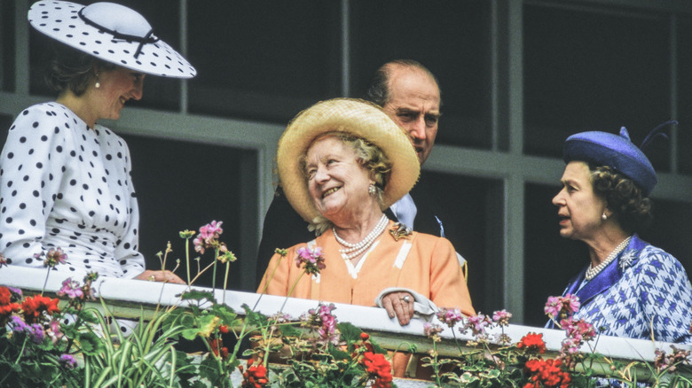 Smiling Princess Diana and the Queen Mother making conversation with Queen Elizabeth II standing to the right.