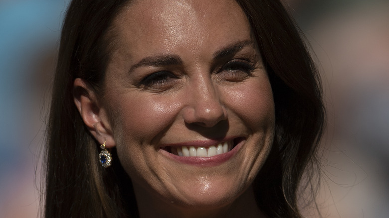 Kate Middleton smiling in a polka dotted dress at Wimbledon
