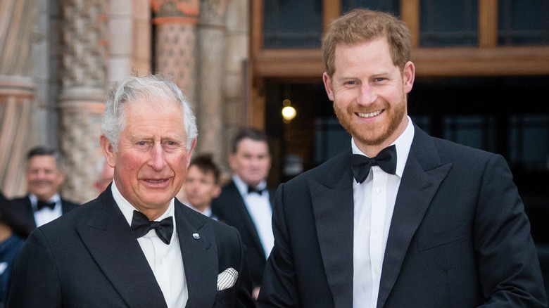 King Charles III and Prince Harry posing together in tuxedos