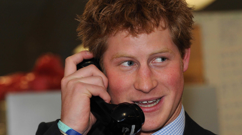 A young Prince Harry speaking on the phone in 2008