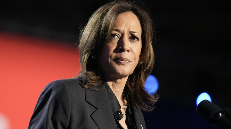 Kamala Harris looking serious in a black blazer and shirt