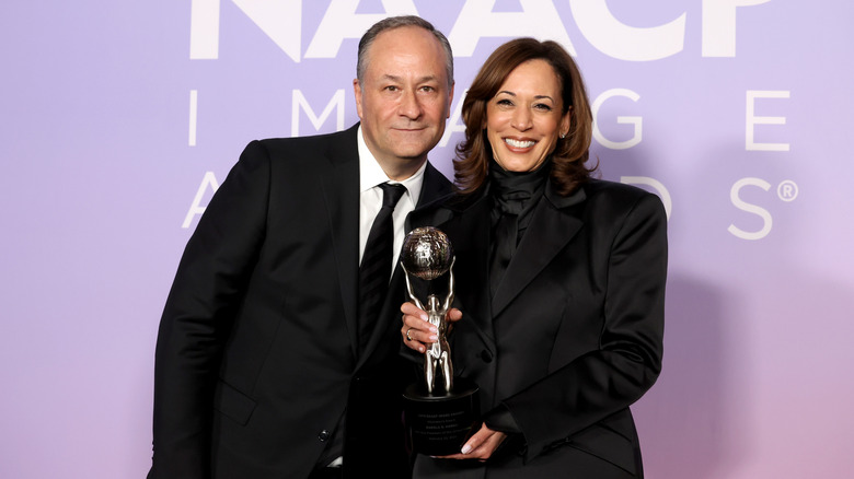 Kamala Harris and Doug Emhoff posing on the red carpet together and smiling