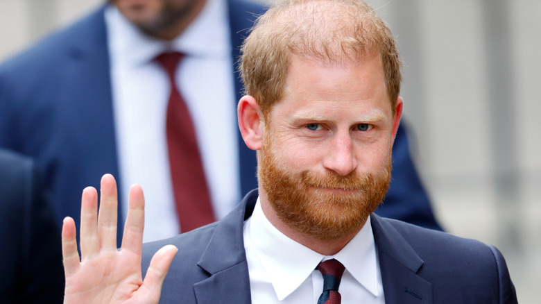 Prince Harry holding hand up