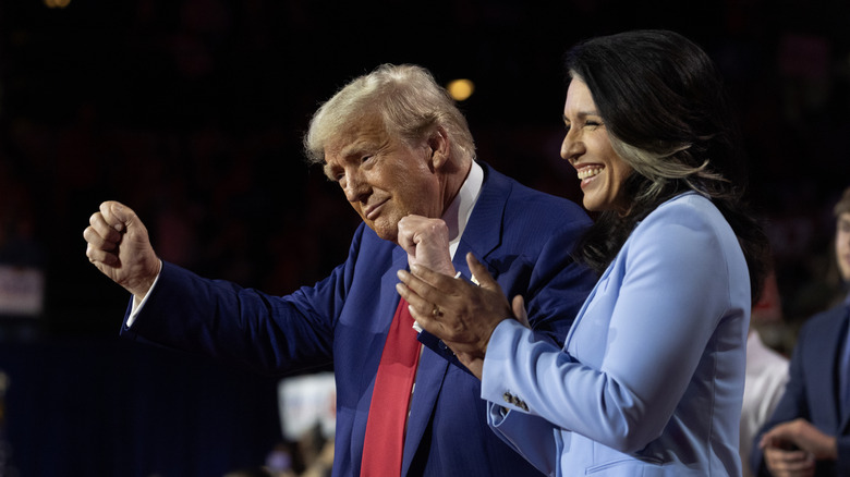 Tulsi Gabbard claps as Donald Trump does his fist pump dance.