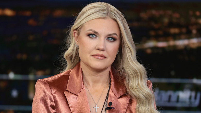 Erika Kirk bronze blouse looking at camera