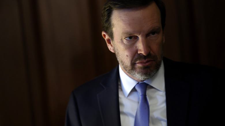 Chris Murphy looking serious in a black suit with a light blue tie