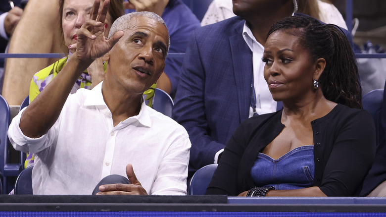 Michelle Obama looking unimpressed as Barack Obama explains something while gesturing