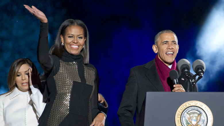 Barack Obama smiling while Michelle Obama waves