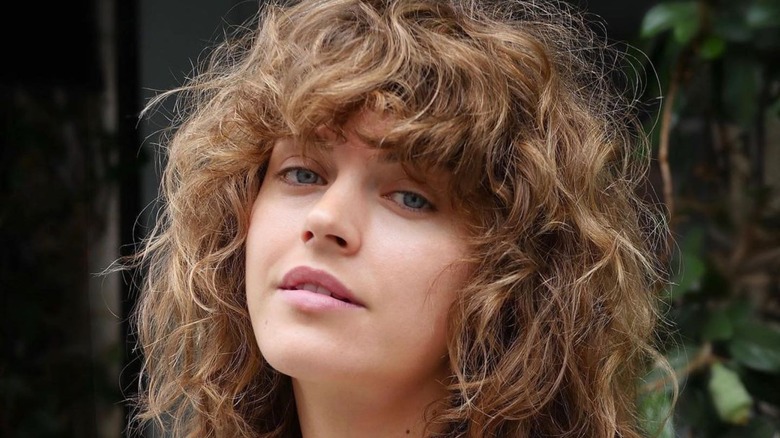 Woman with light brown curly shag