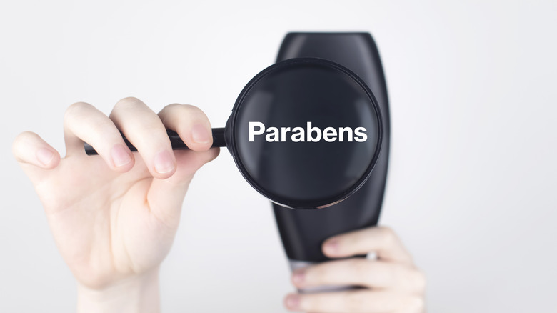 shampoo bottle with magnifying glass showing 'Parabens'