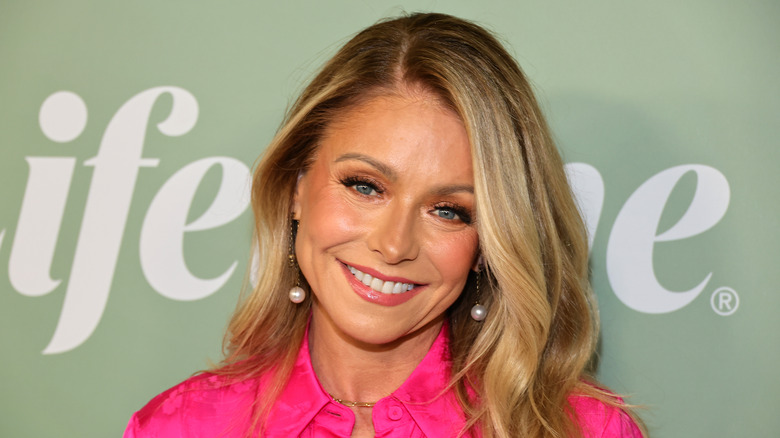 Kelly Ripa smiling in pink shirt