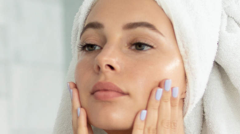 Woman looking at skin in mirror