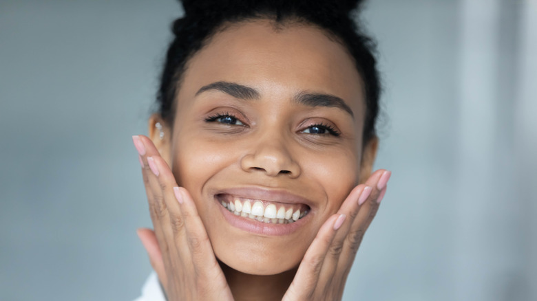 Woman holding her cheeks and smiling