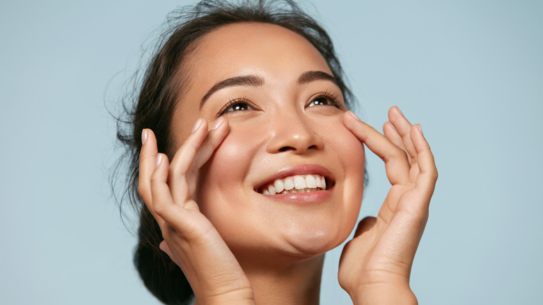 Woman smiling touching face