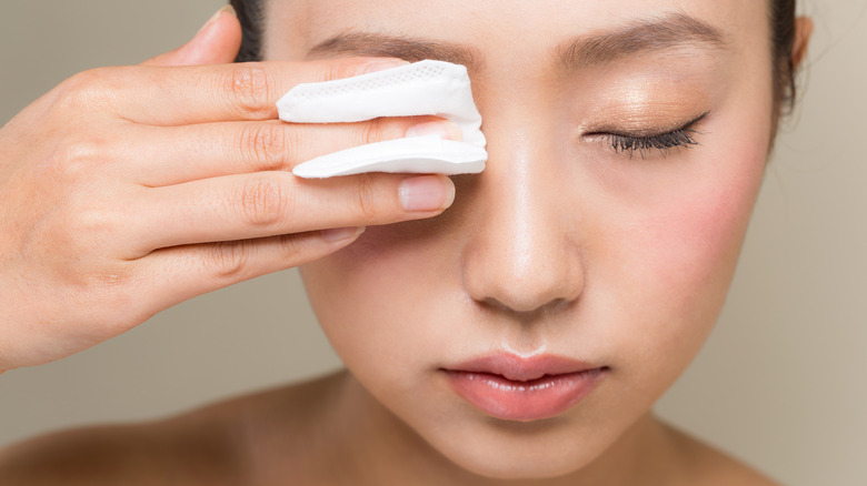 A woman removing eye makeup