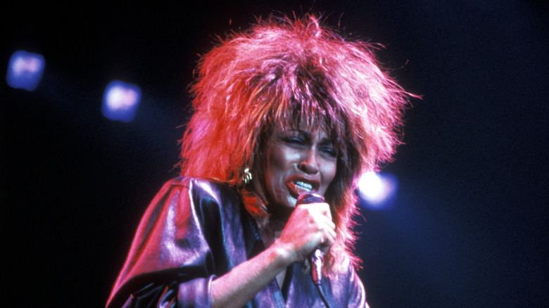 Tina Turner sings into a microphone