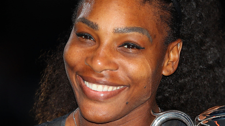 Serena Williams smiling with a trophy