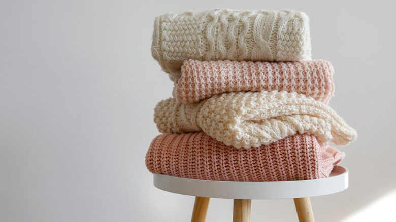 Stack of neutral knit sweaters