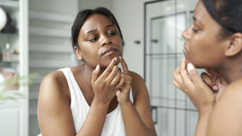 woman squeezing a pimple 