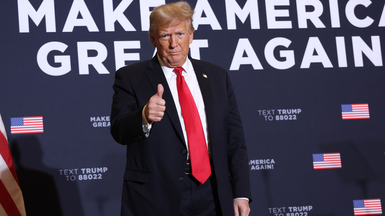 Donald Trump gives thumbs-up MAGA background