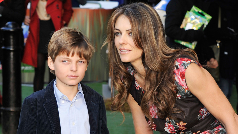 Elizabet Hurley leaning down beside her son, Damian Hurley.