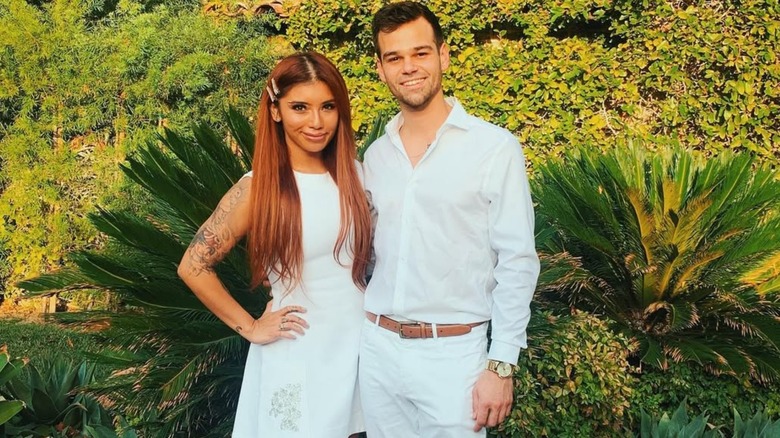 Kirstin Maldonado with straight, red hair posing outdoors with Ben Hausdorff