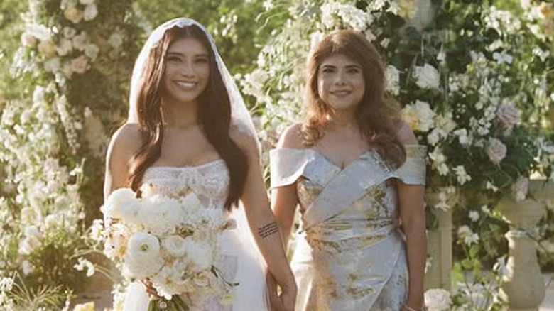 Kirstin Maldonado posing in her strapless lace wedding dress with a friend