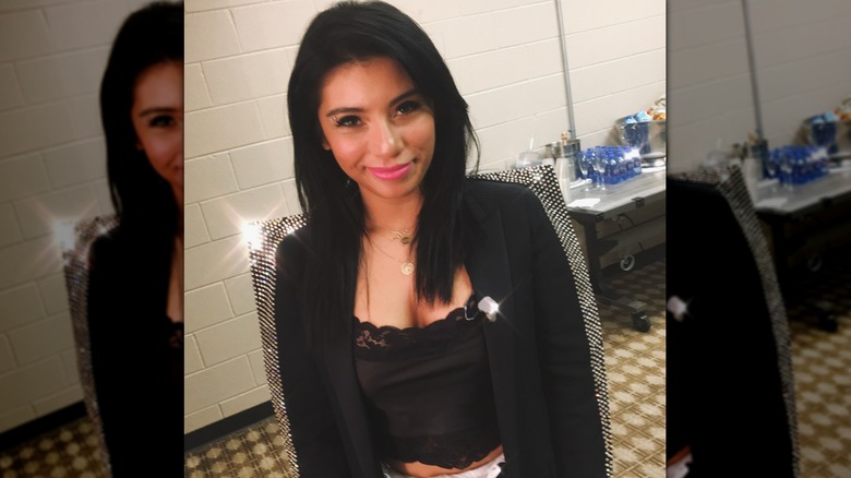 Kirstin Maldonado with black hair wearing a black lace cami and blazer