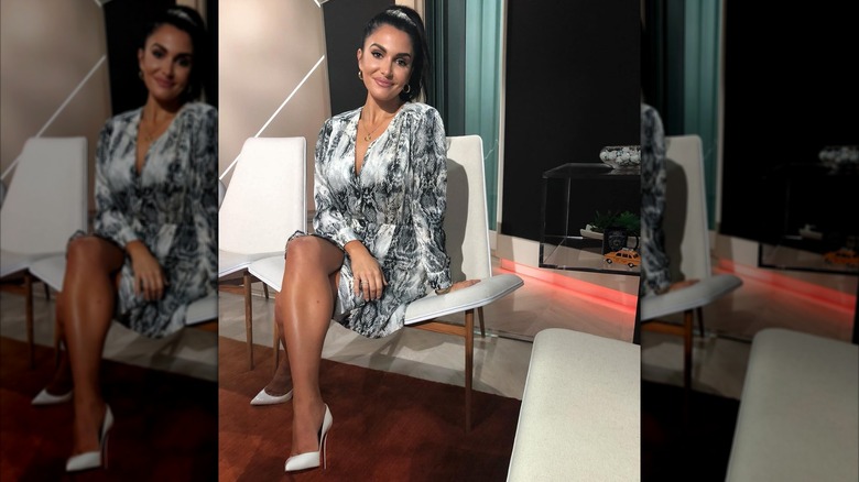 Molly Qerim sitting in a black white and gray snakeskin pattern dress.