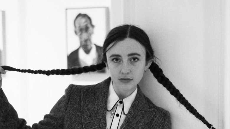 Angelica Jopling holding her braids at her art gallery.