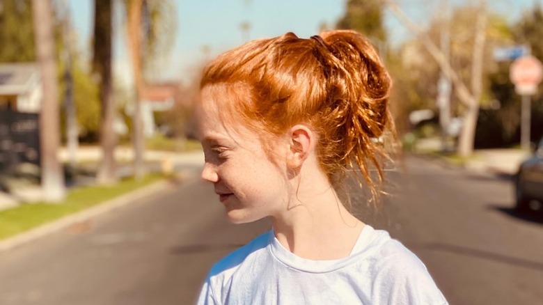 Jessie Phoenix Jopling as a child looking to the side on a sunny street