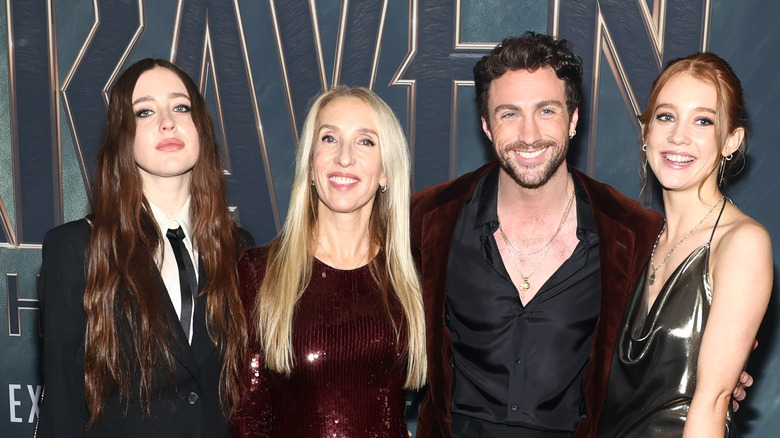 Aaron Taylor-Johnson smiles while posing on the red carpet for "Kraven" with his stepdaughters and wife