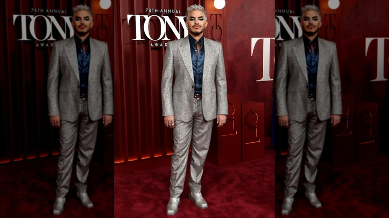 Adam Lamber posing at the Tony awards in a silver suit with matching silver hair