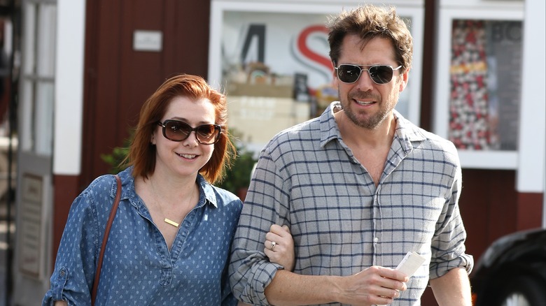 Alyson Hannigan holding Alexis Denisof's arm